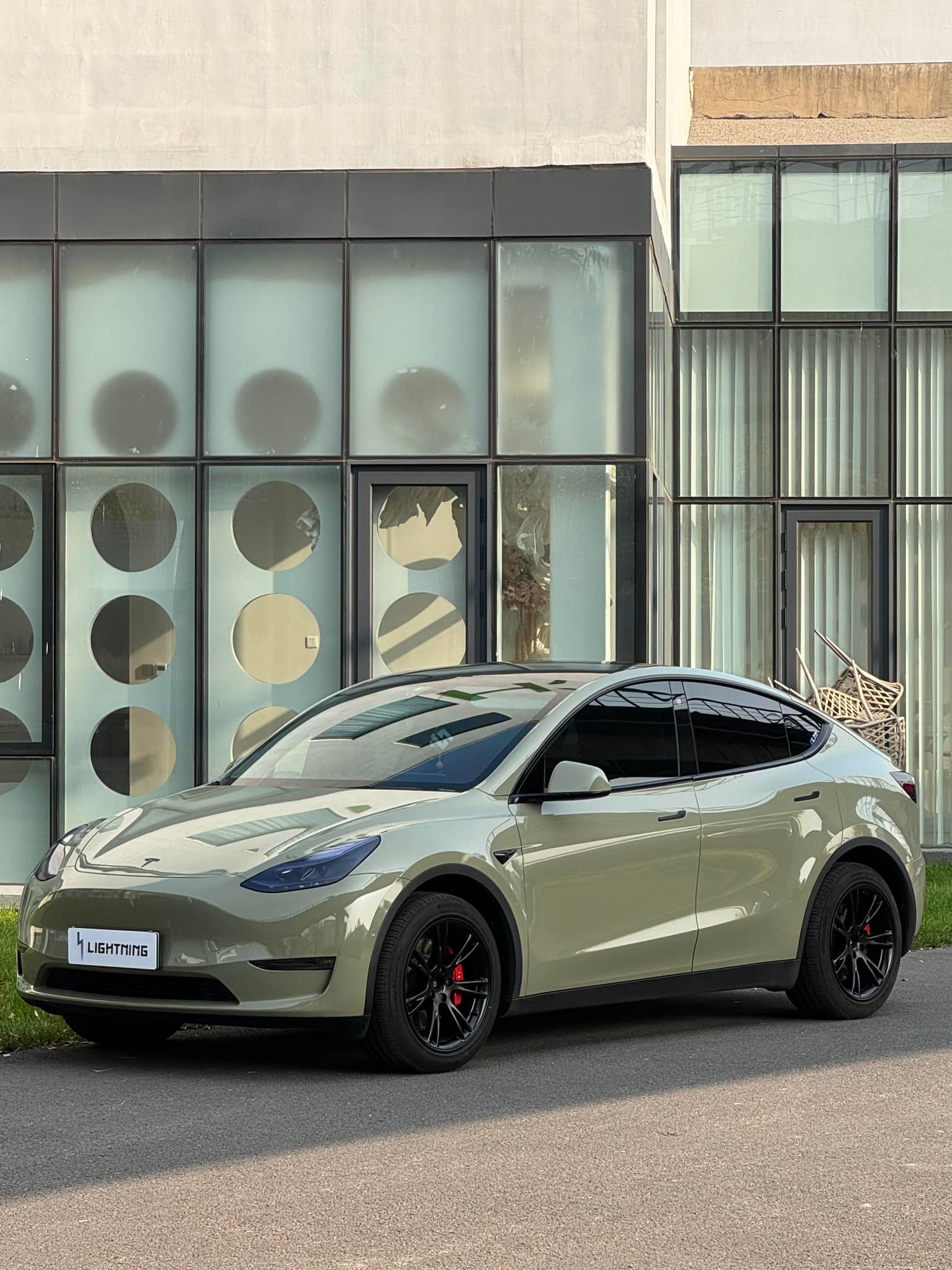 Tesla car wrapped with Pre-cut Tesla Vinyl Wrap Kit by WrapBug in matte green color parked outdoors