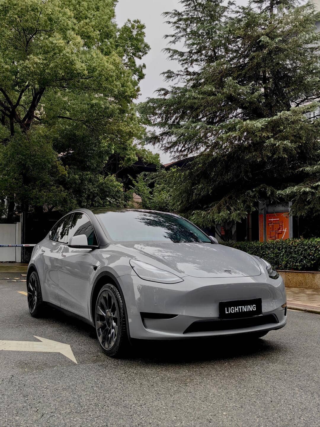 Gray Tesla Model Y with a smooth finish using WrapBug Pre-cut Tesla Vinyl Wrap Kit parked near trees