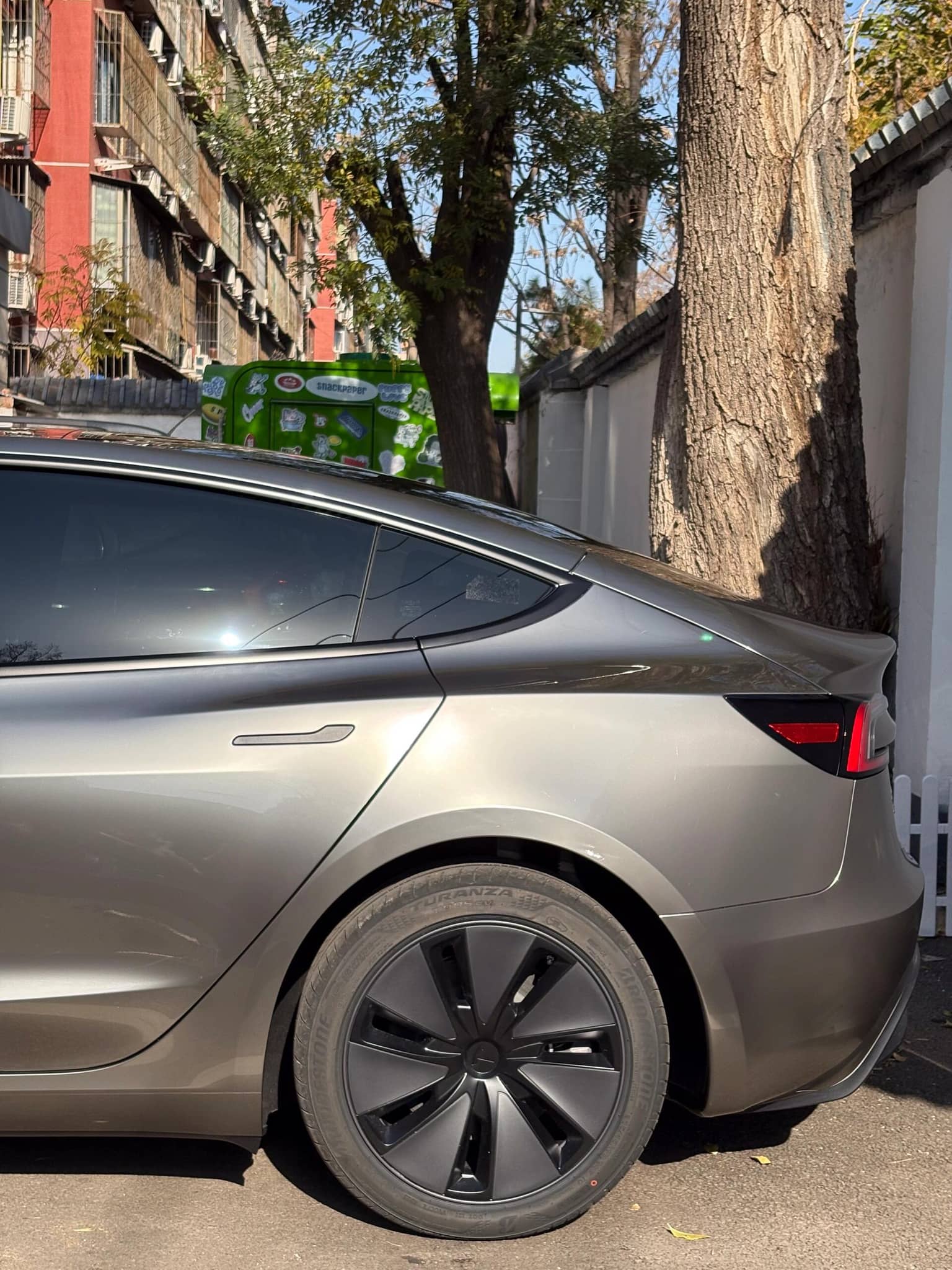 Silver Tesla Model 3 with glossy finish showing rear side wrapped using Pre-cut Tesla Wrap Kit by WrapBug