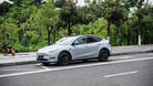 Silver Tesla Model Y parked on street showcasing WrapBug pre-cut Tesla wrap kit application