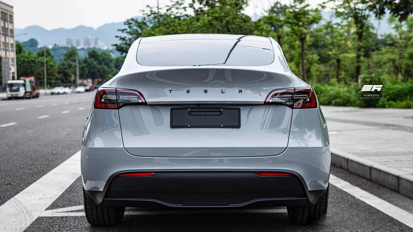 Rear view of white Tesla Model Y featuring a Pre-cut Tesla Wrap Kit by WrapBug on a city street