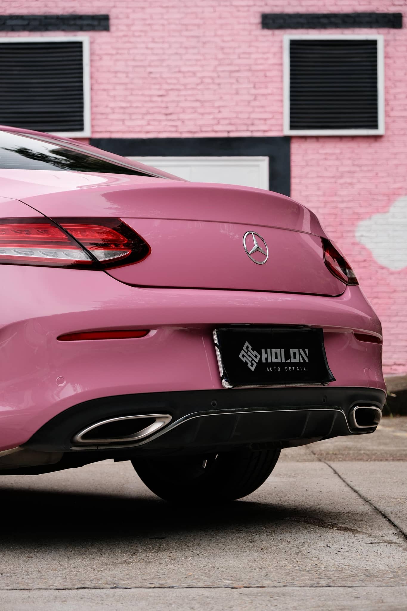Pink luxury car rear view wrapped with Pre-cut Tesla Wrap Kit by WrapBug in an urban setting