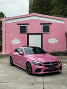 Pink Mercedes parked in front of pink house wall showcasing Pre-cut Tesla Wrap Kit by WrapBug