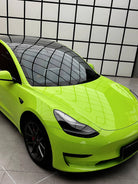 Bright green Tesla with glossy finish using Pre-cut Tesla Wrap Kit by WrapBug in modern showroom