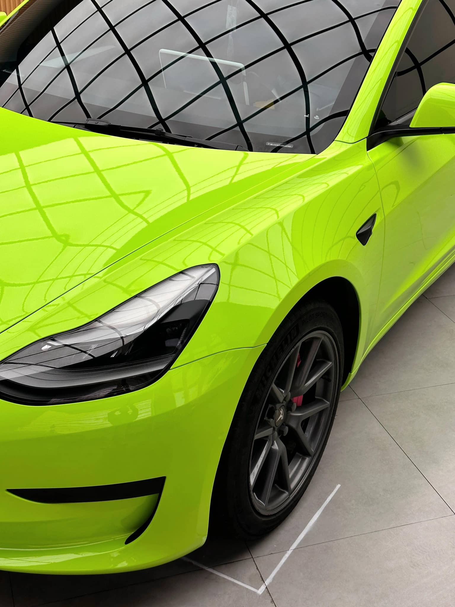 Bright green Tesla Model 3 with a glossy finish applied using a Pre-cut Tesla Wrap Kit by WrapBug