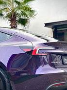 Glossy purple Tesla Model Y rear with Pre-cut Tesla Wrap Kit by WrapBug applied under palm trees