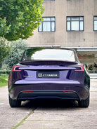 Rear view of a Tesla Model 3 wrapped in a glossy dark purple color using a Pre-cut Tesla Wrap Kit by WrapBug
