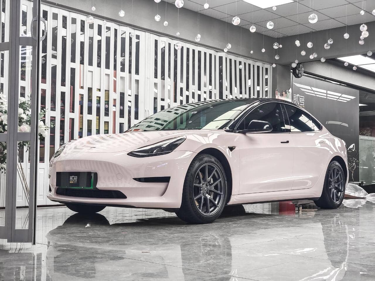 White Tesla Model 3 wrapped with a Pre-cut Tesla Wrap Kit by WrapBug in a showroom