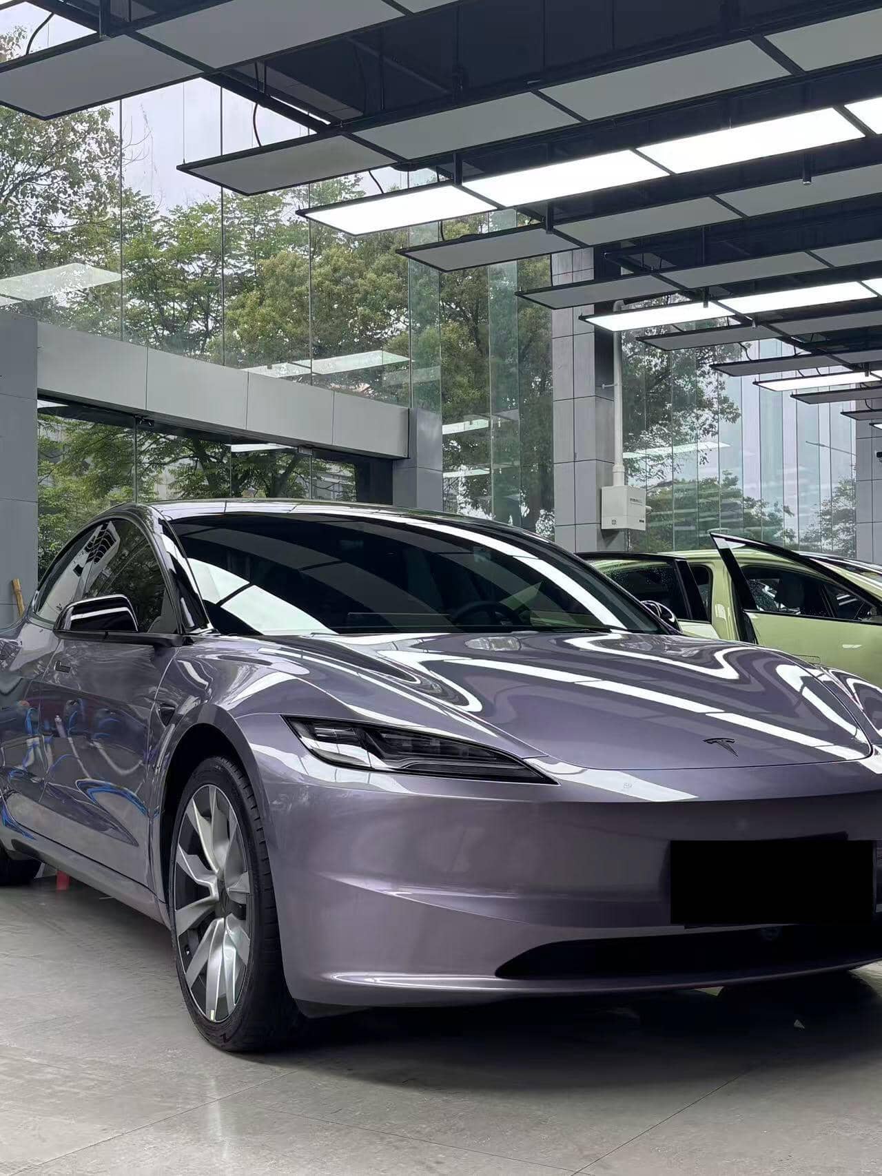 Tesla car with glossy purple finish using a Pre-cut Tesla Wrap Kit by WrapBug in a showroom