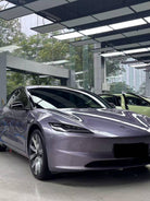 Tesla car with glossy purple finish using a Pre-cut Tesla Wrap Kit by WrapBug in a showroom