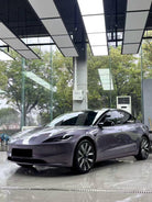 Sleek gray Tesla Model 3 wrapped with Pre-cut Tesla Vinyl Wrap Kit parked inside modern showroom