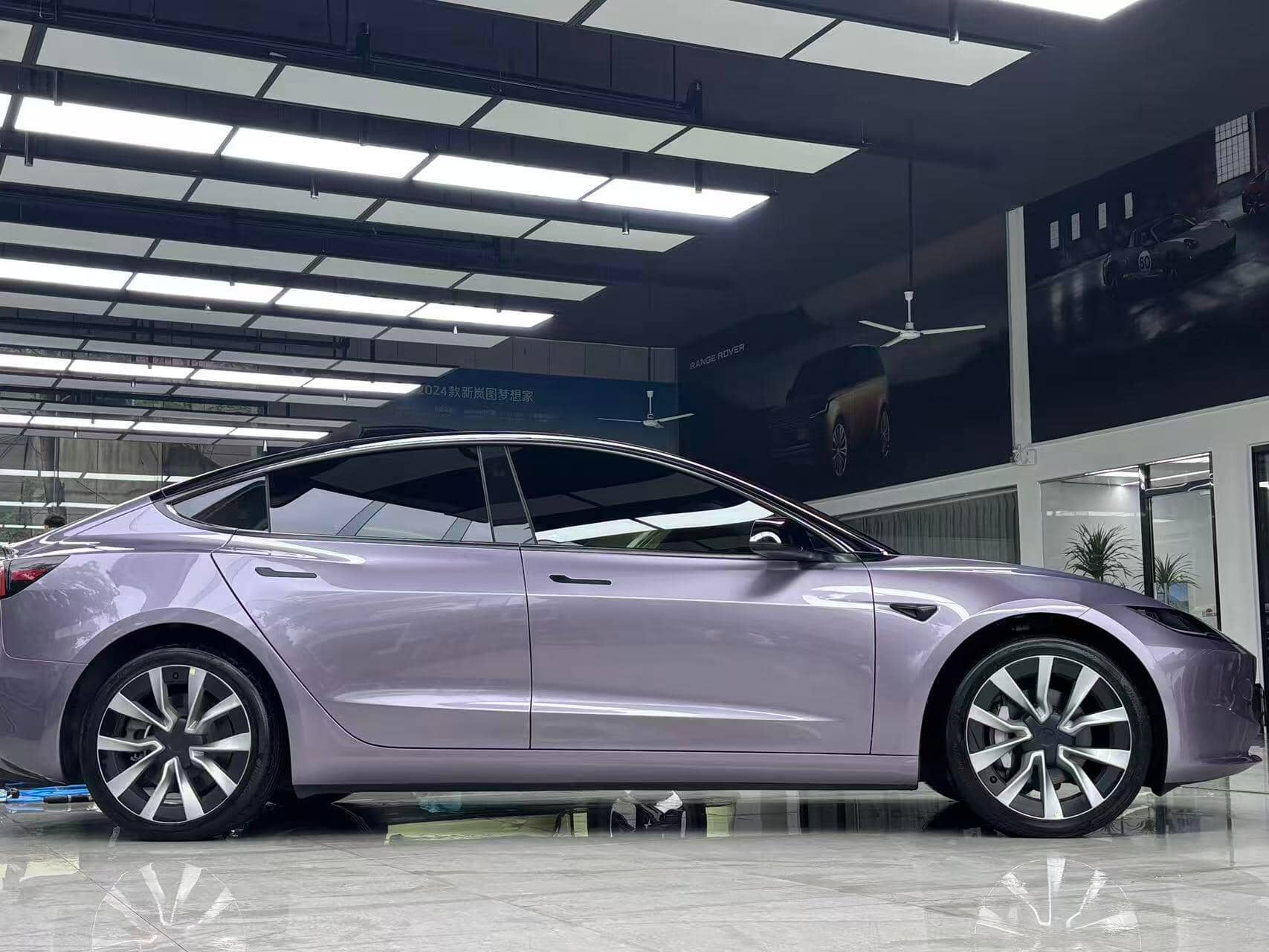 Tesla Model 3 wrapped in purple using WrapBug Pre-cut Tesla Wrap Kit in a showroom