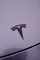 Purple Tesla hood with black logo covered in water droplets showcasing Pre-cut Tesla Wrap Kit