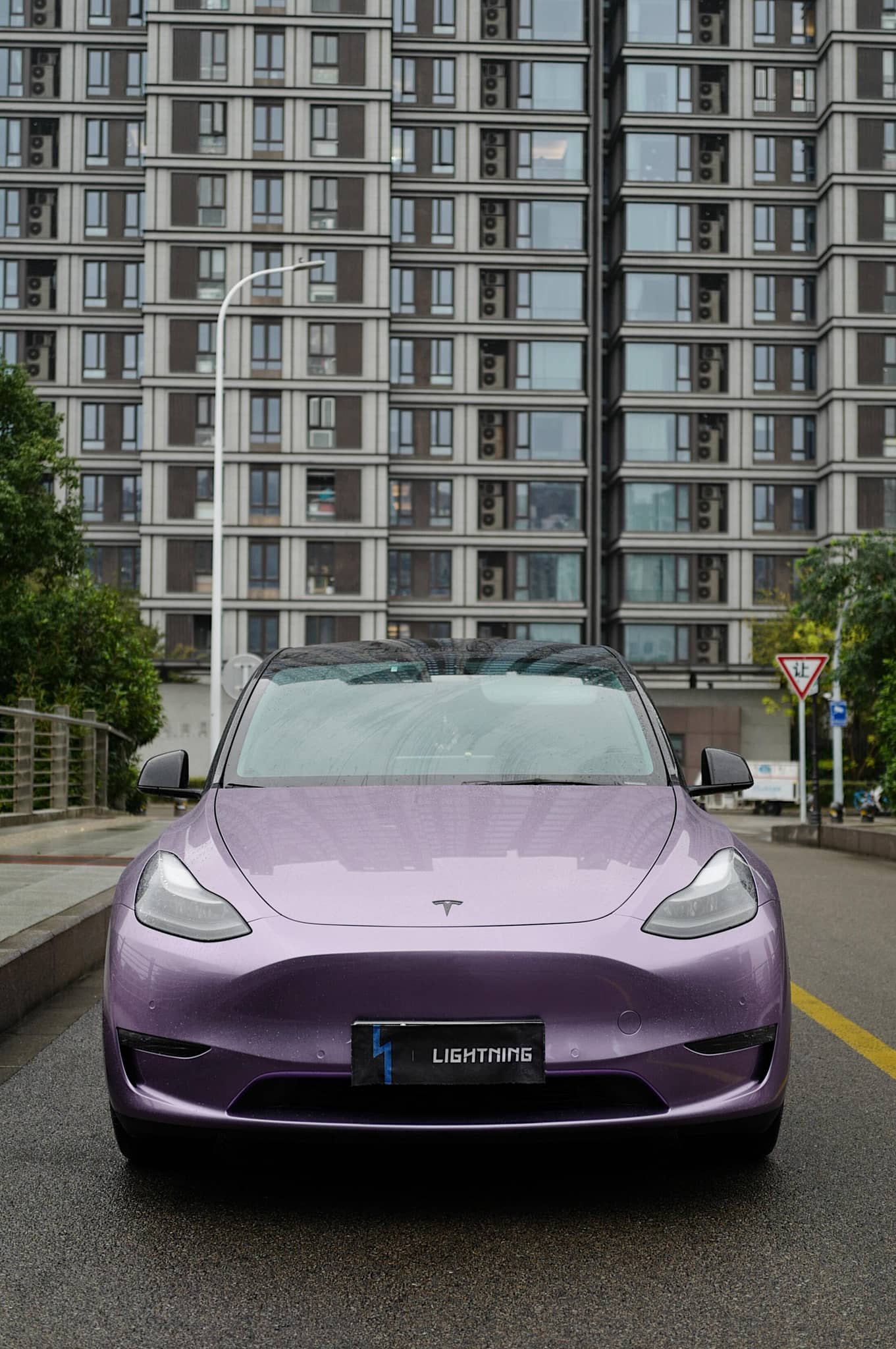 Purple Tesla Model 3 covered with Pre-cut Tesla Wrap Kit parked on urban street with buildings
