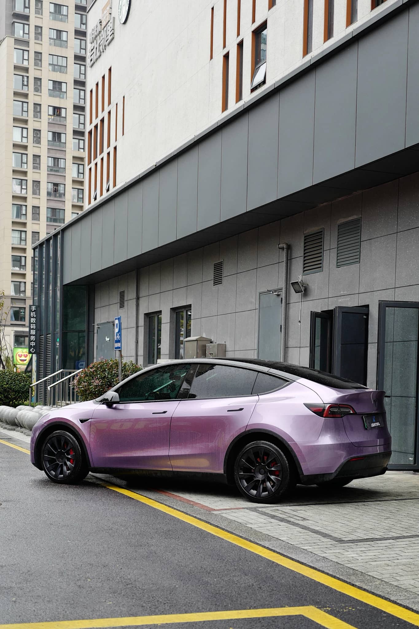 Purple Tesla Model Y wrapped with a Pre-cut Tesla Wrap Kit parked on city street near modern building