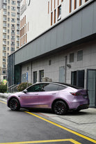 Purple Tesla Model Y wrapped with a Pre-cut Tesla Wrap Kit parked on city street near modern building
