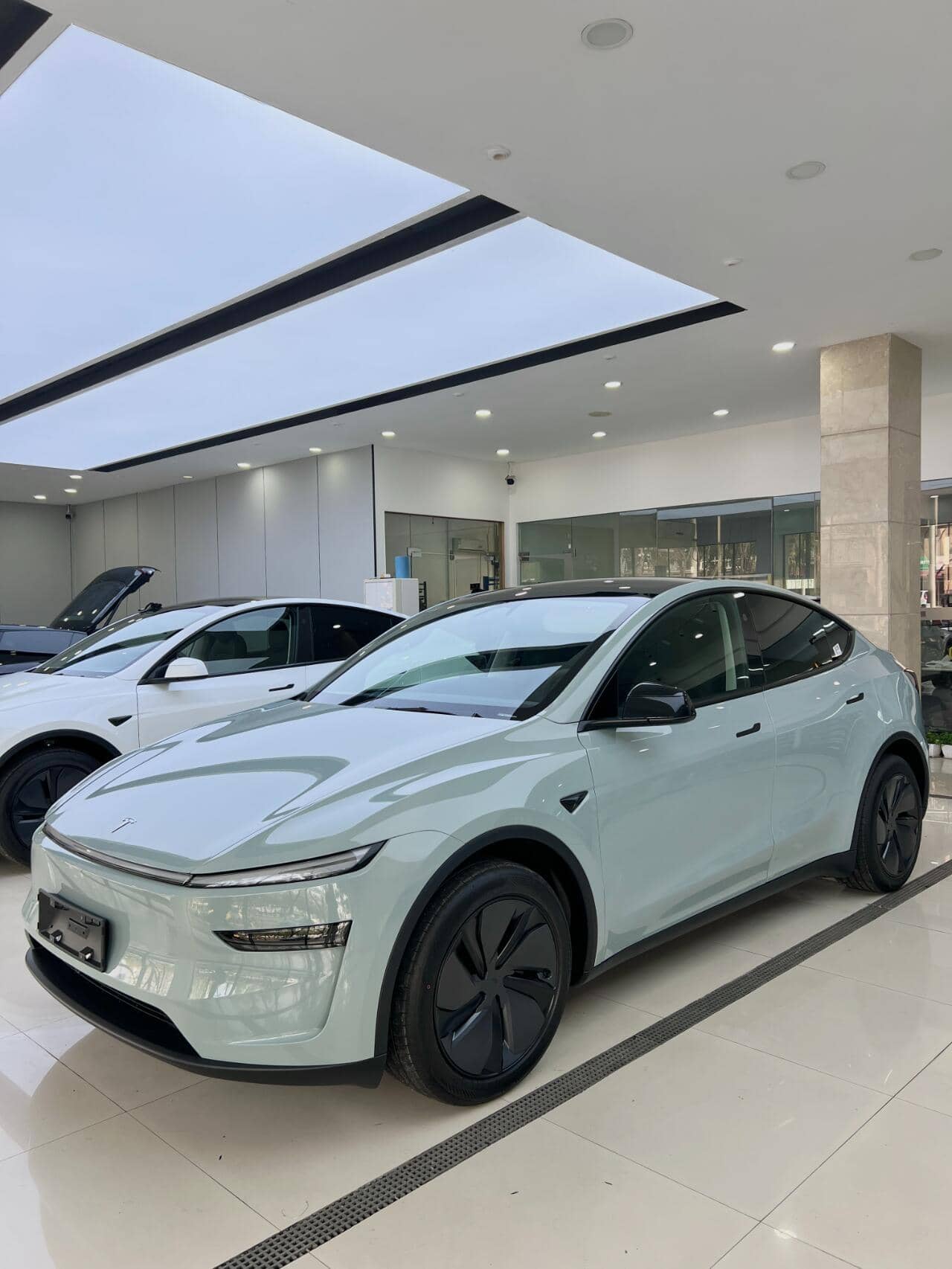 White Tesla SUV featuring sleek design with tesla color PPF in a bright showroom