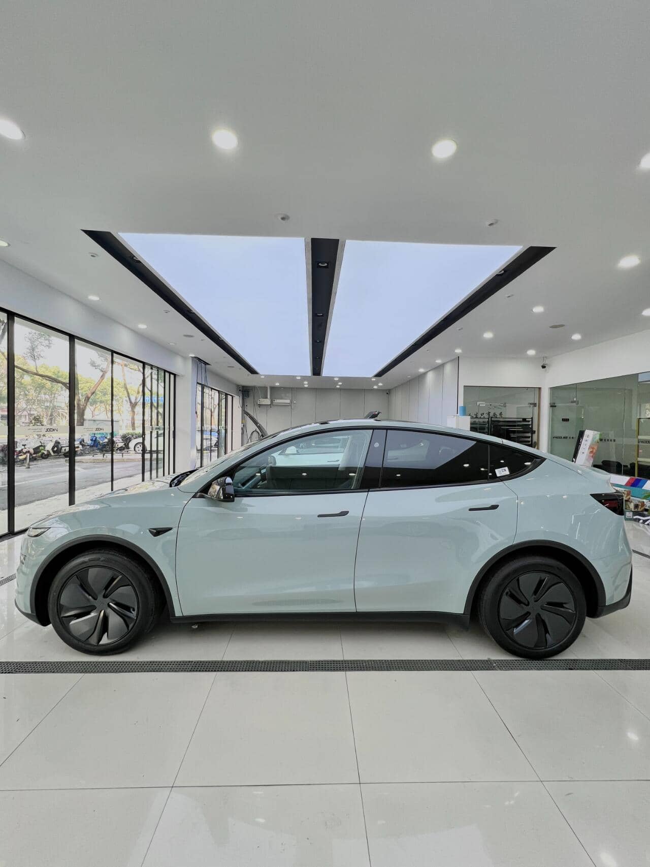 White Tesla electric car protected with tesla color PPF film displayed in a bright showroom