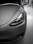 Close-up of a sleek gray car headlight with matte finish wrap by WrapBug