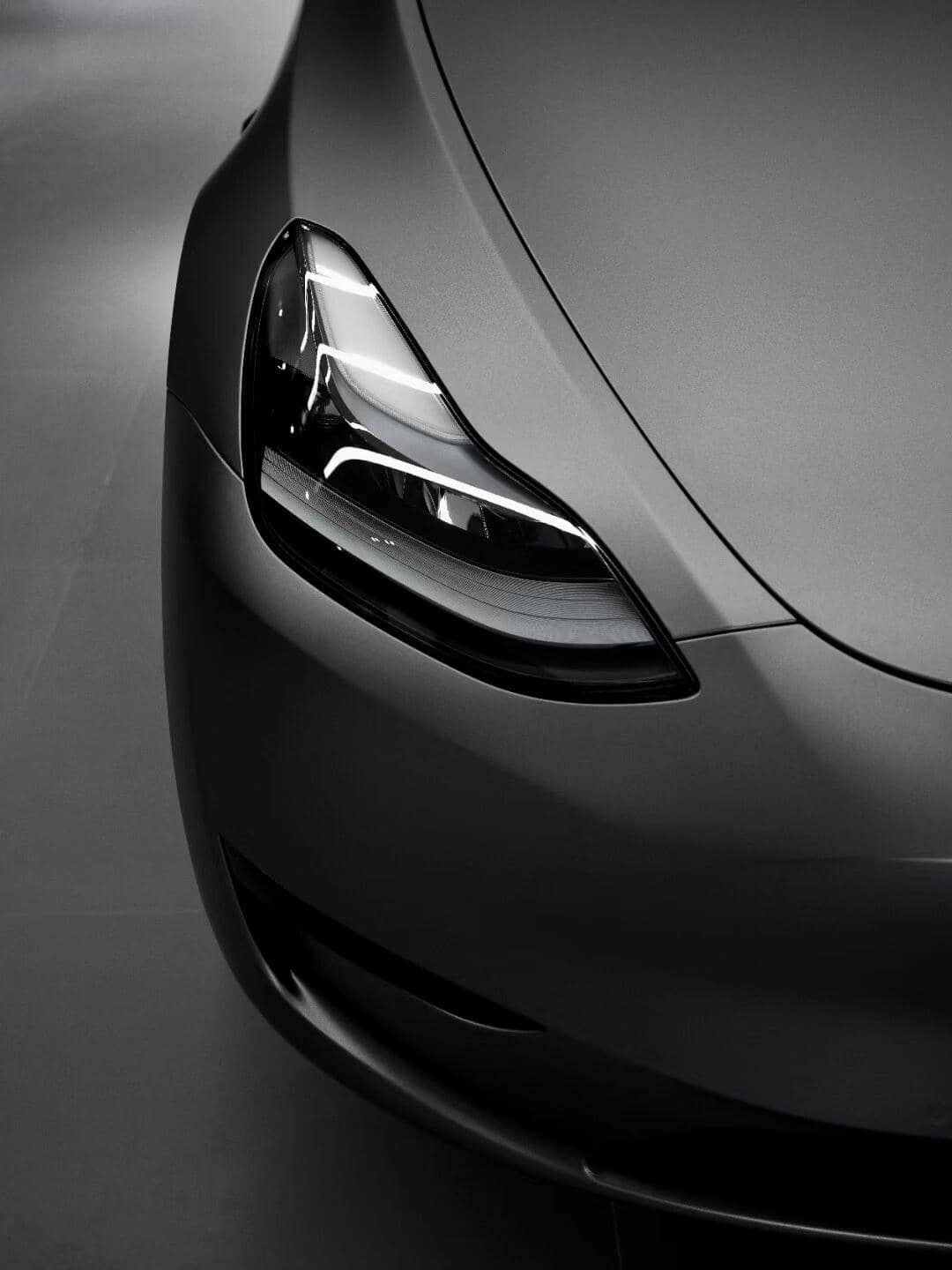 Close-up of a sleek matte gray car front headlight showcasing modern automotive design
