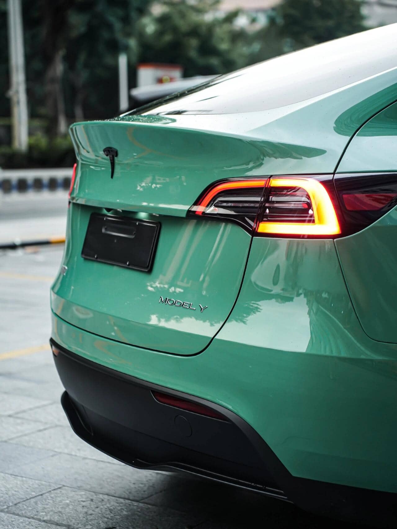 Green Tesla Model Y rear view with Pre-cut Tesla Vinyl Wrap Kit applied by WrapBug