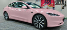 Pink Tesla Model 3 wrapped with WrapBug Pre-cut Tesla Vinyl Wrap Kit in a garage