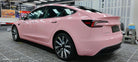 Pink Tesla Model 3 wrapped using Pre-cut Tesla Vinyl Wrap Kit by WrapBug in a professional garage