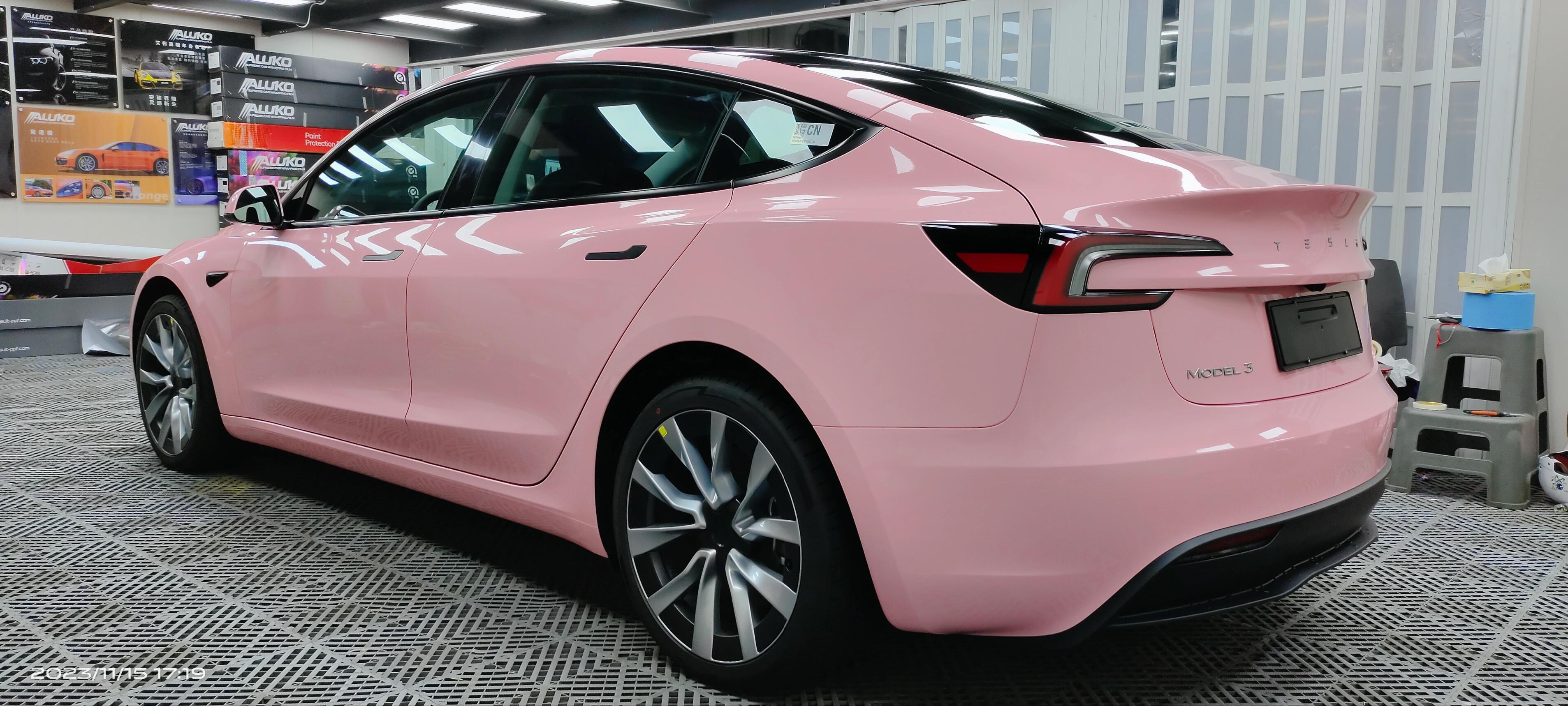 Pink Tesla Model 3 wrapped using Pre-cut Tesla Vinyl Wrap Kit by WrapBug in a professional garage