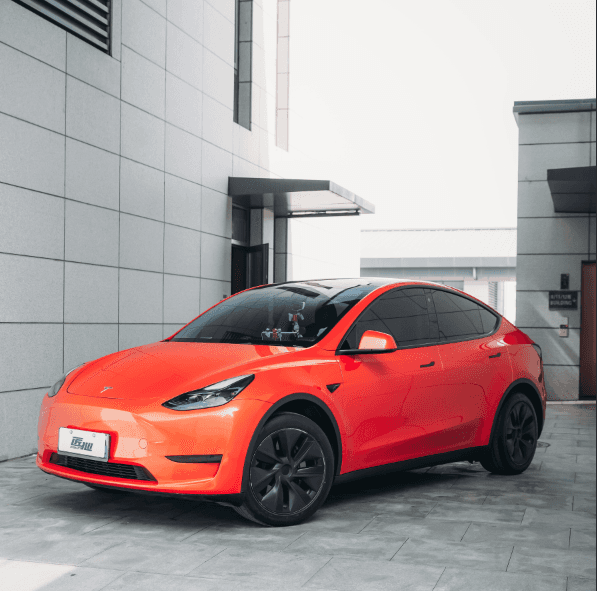 Red Tesla parked outdoors showcasing color from Pre-cut Tesla Wrap Kit by WrapBug