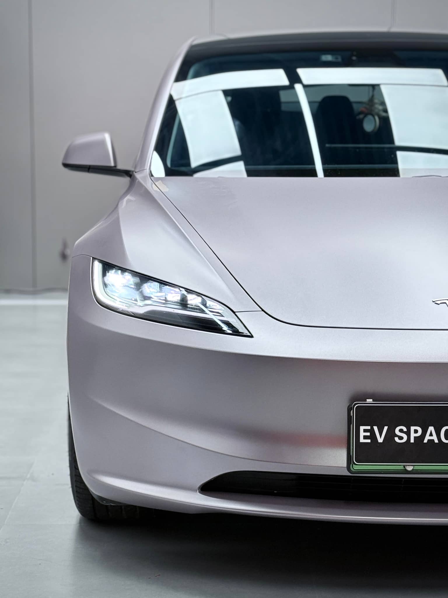 Front view of a Tesla car featuring a smooth silver tesla vinyl wrap with sleek headlights