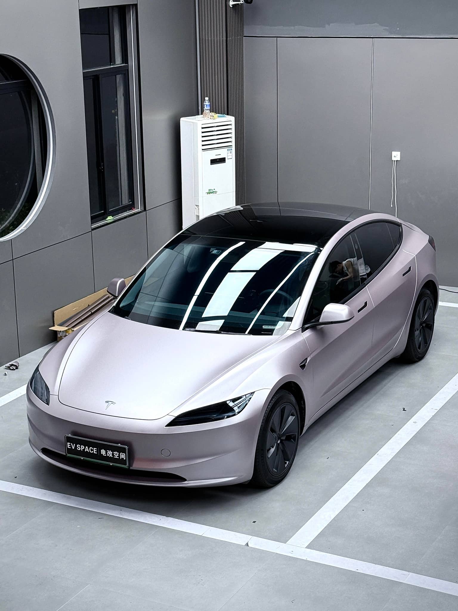 Tesla car wrapped with sleek matte tesla vinyl wrap parked indoors in modern garage