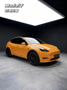 Orange Tesla Model Y featuring WrapBug pre-cut Tesla wrap kit for a sleek custom finish