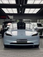 Front view of sleek silver Tesla Model X electric car with WrapBug branding in a showroom