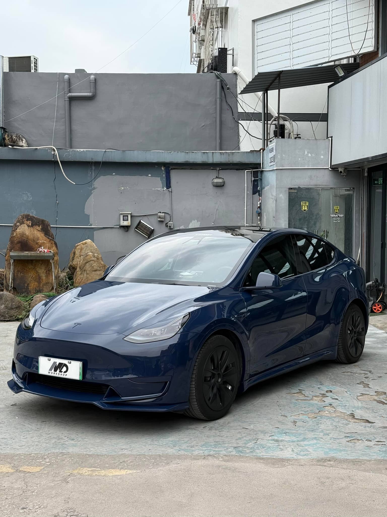 Blue Tesla Model 3 wrapped with Pre-cut Tesla Vinyl Wrap Kit parked in an urban outdoor setting