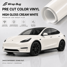 Pre-cut Tesla vinyl wrap kit in high gloss cream white applied on a white Tesla car with roll of vinyl wrap