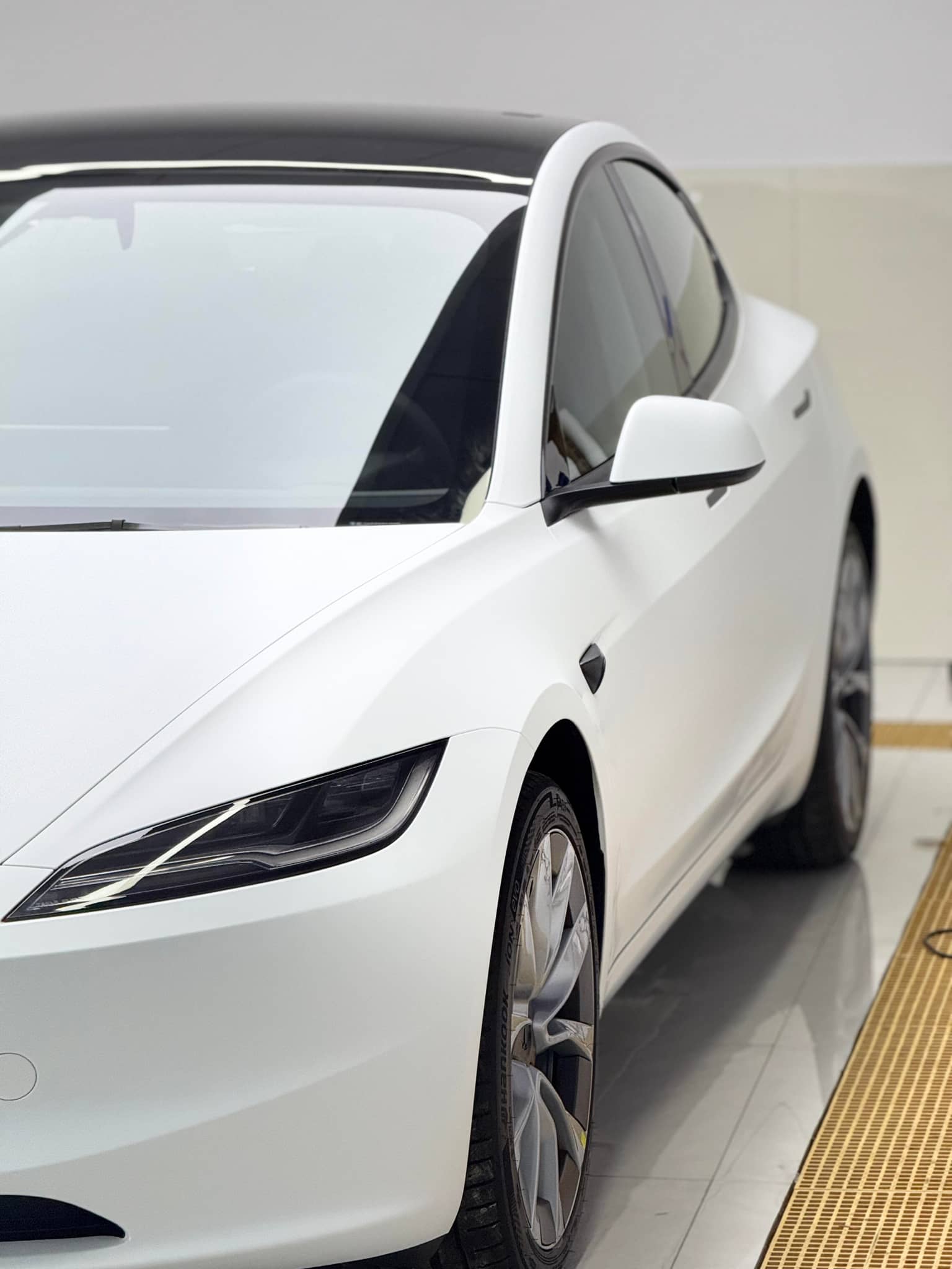 White Tesla Model 3 featuring Pre-cut Tesla Vinyl Wrap Kit by WrapBug on front side and wheel