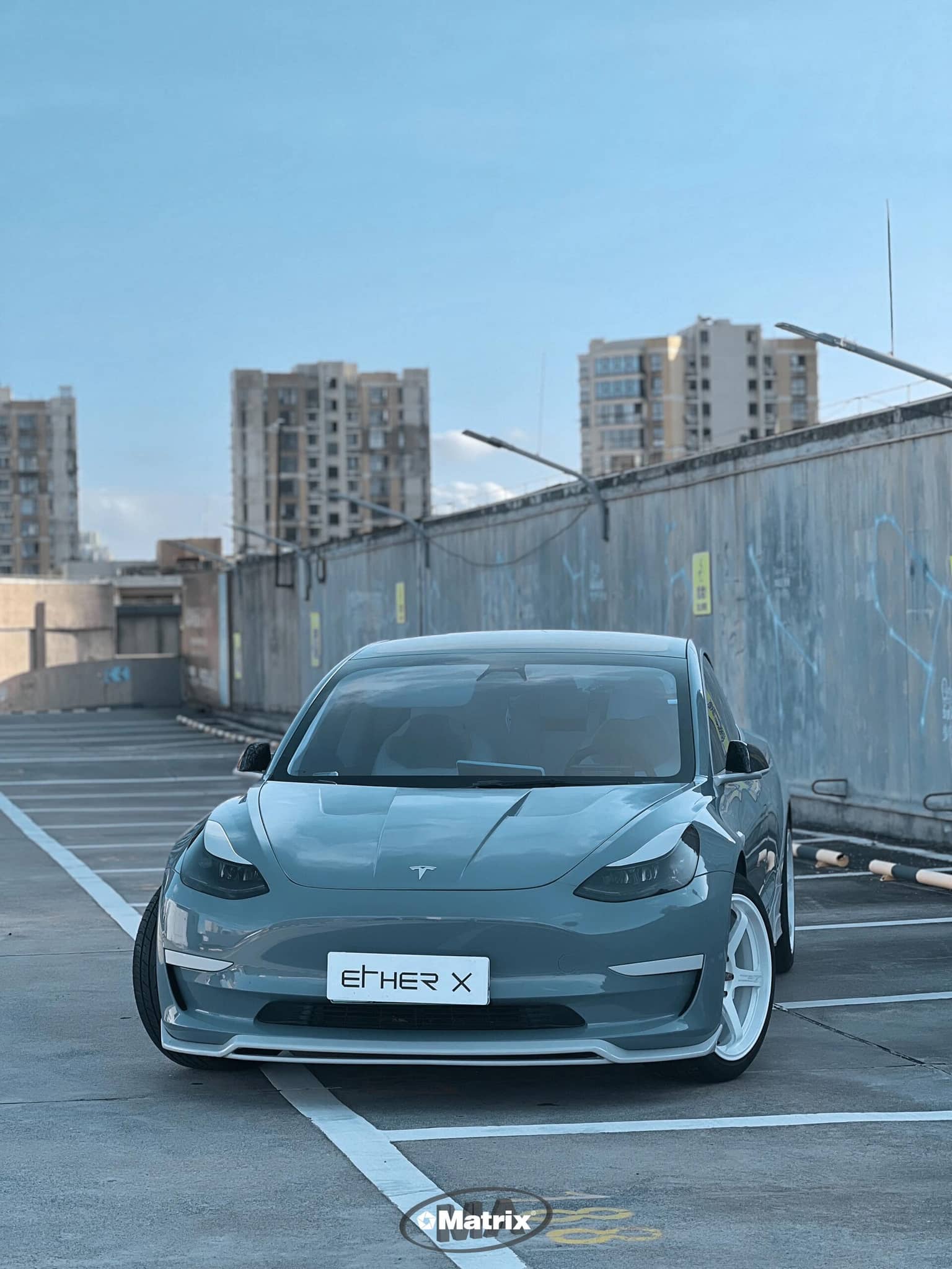 Tesla car parked in rooftop lot showcasing Pre-cut Tesla Vinyl Wrap Kit by WrapBug on front hood and body