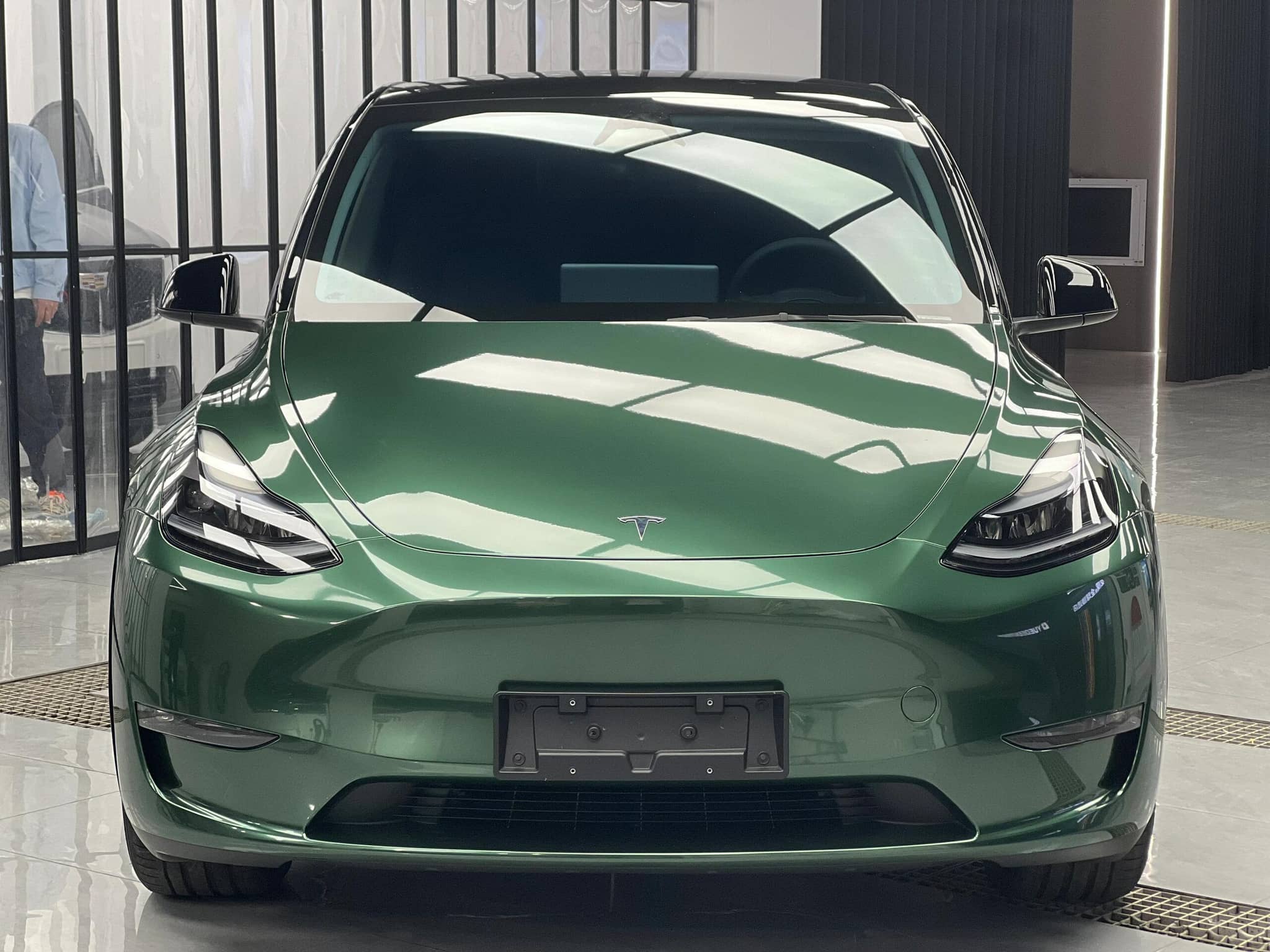 Green Tesla Model Y with shiny finish showcasing WrapBug Pre-cut Tesla Wrap Kit for vehicle customization
