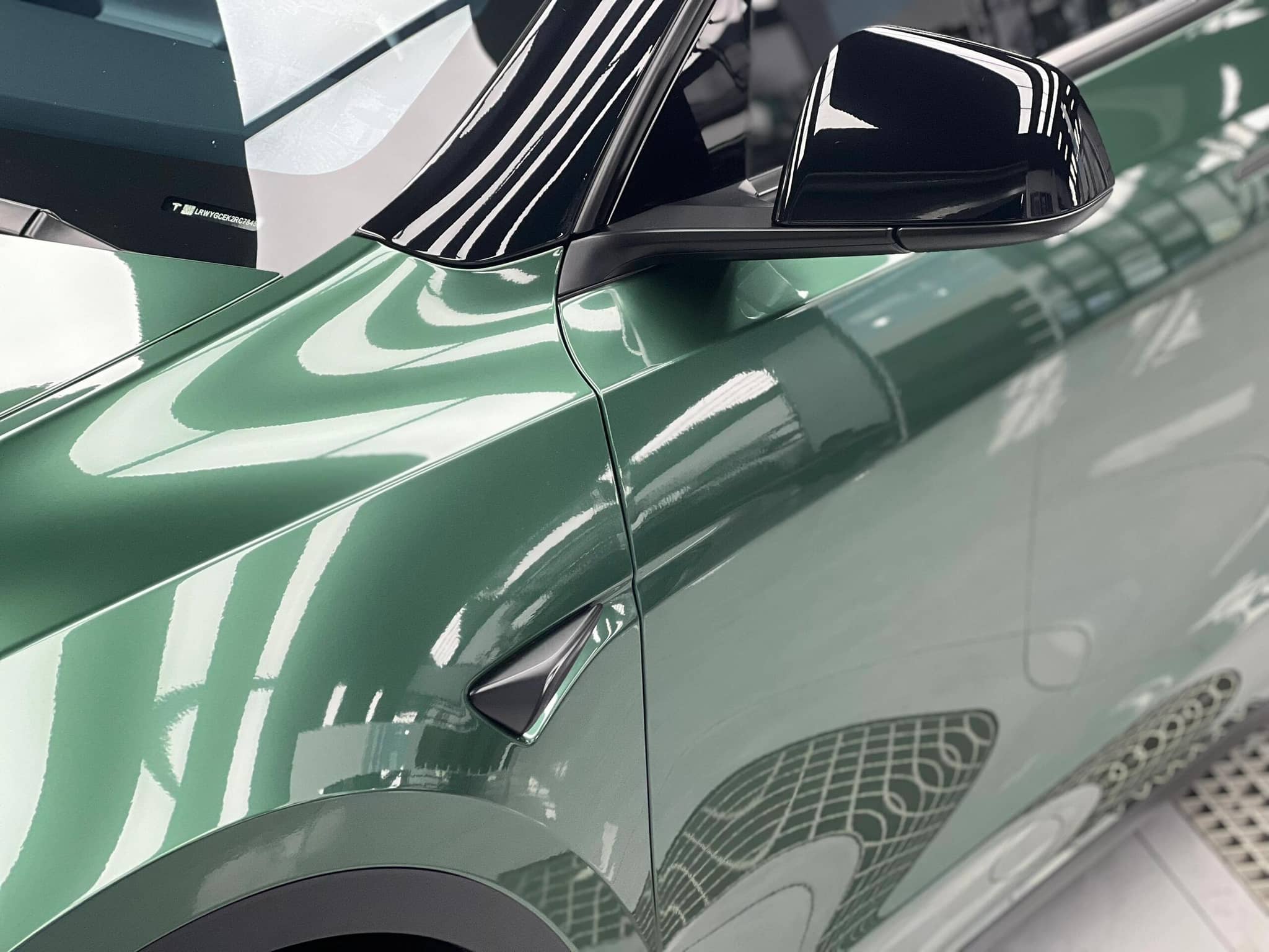 Close-up of green Tesla with glossy finish using Pre-cut Tesla Wrap Kit by WrapBug